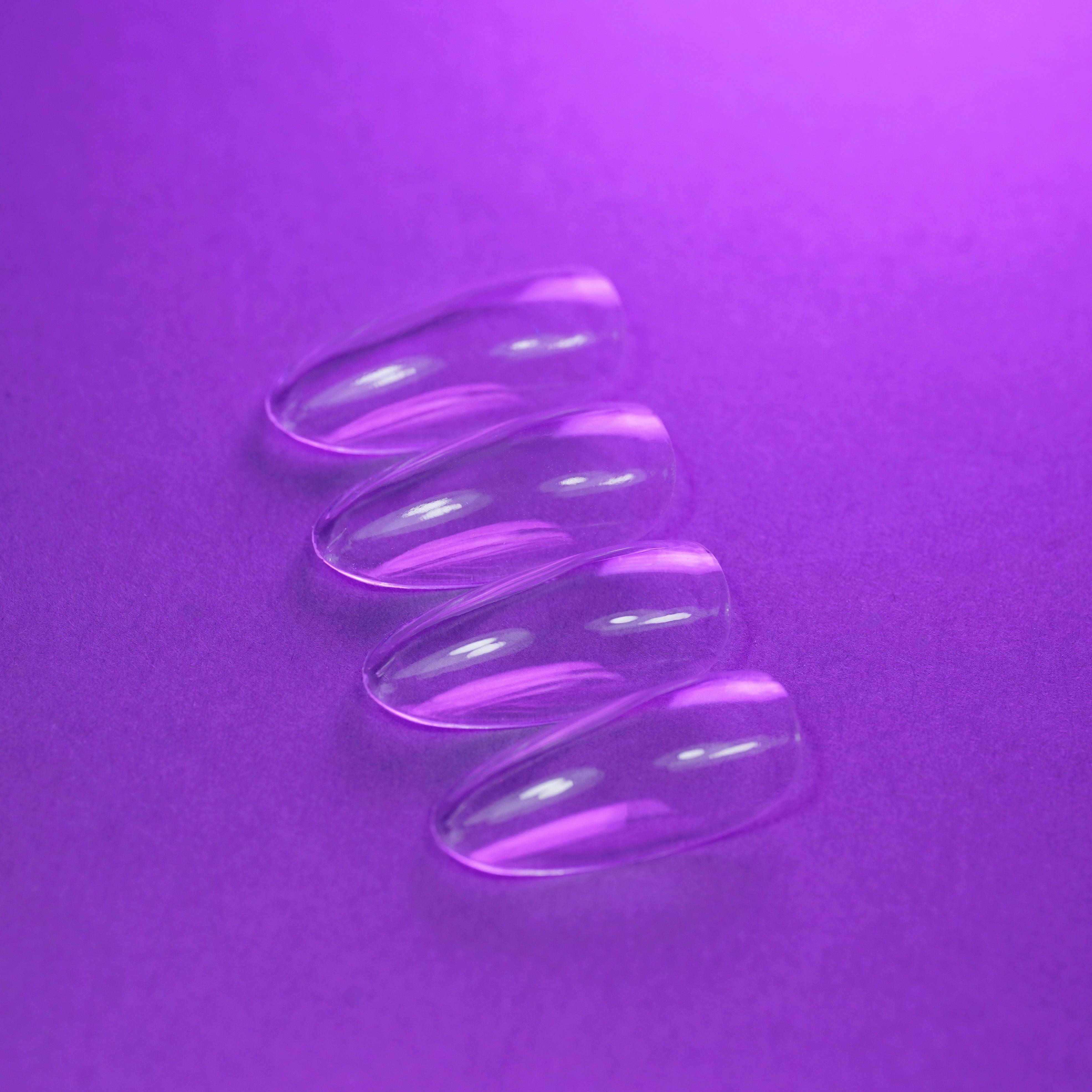 Capsules américaines transparentes en forme medium amande natural – vue détaillée montrant leur courbure naturelle