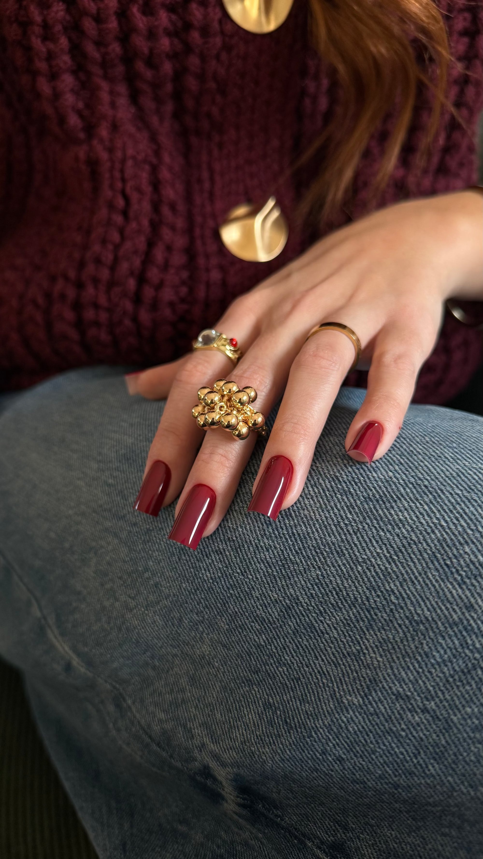 Vernis semi-permanent rouge bordeaux Gel polish 501 porté sur ongles carrés, associé à des bijoux dorés